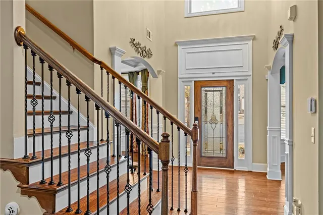 a view of a hallway with wooden floor and stairs