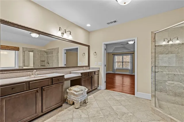a bathroom with a granite countertop sink a mirror and a bathtub