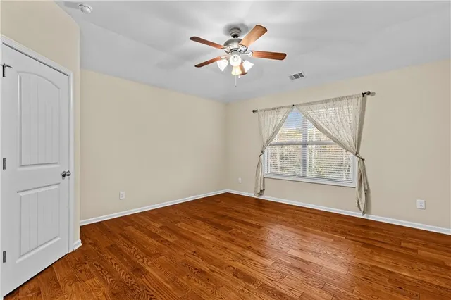 a view of a room with a ceiling fan and front door