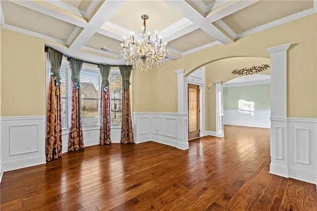 an empty room with windows fireplace and wooden floor