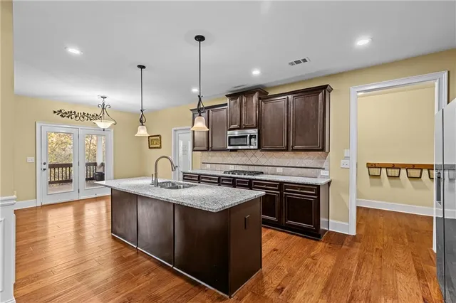 a kitchen with stainless steel appliances granite countertop a sink stove and refrigerator