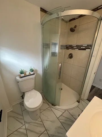 a bathroom with a toilet and a shower