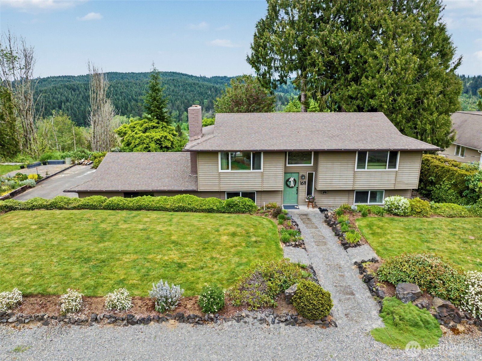 a aerial view of a house with a yard plants and large tree