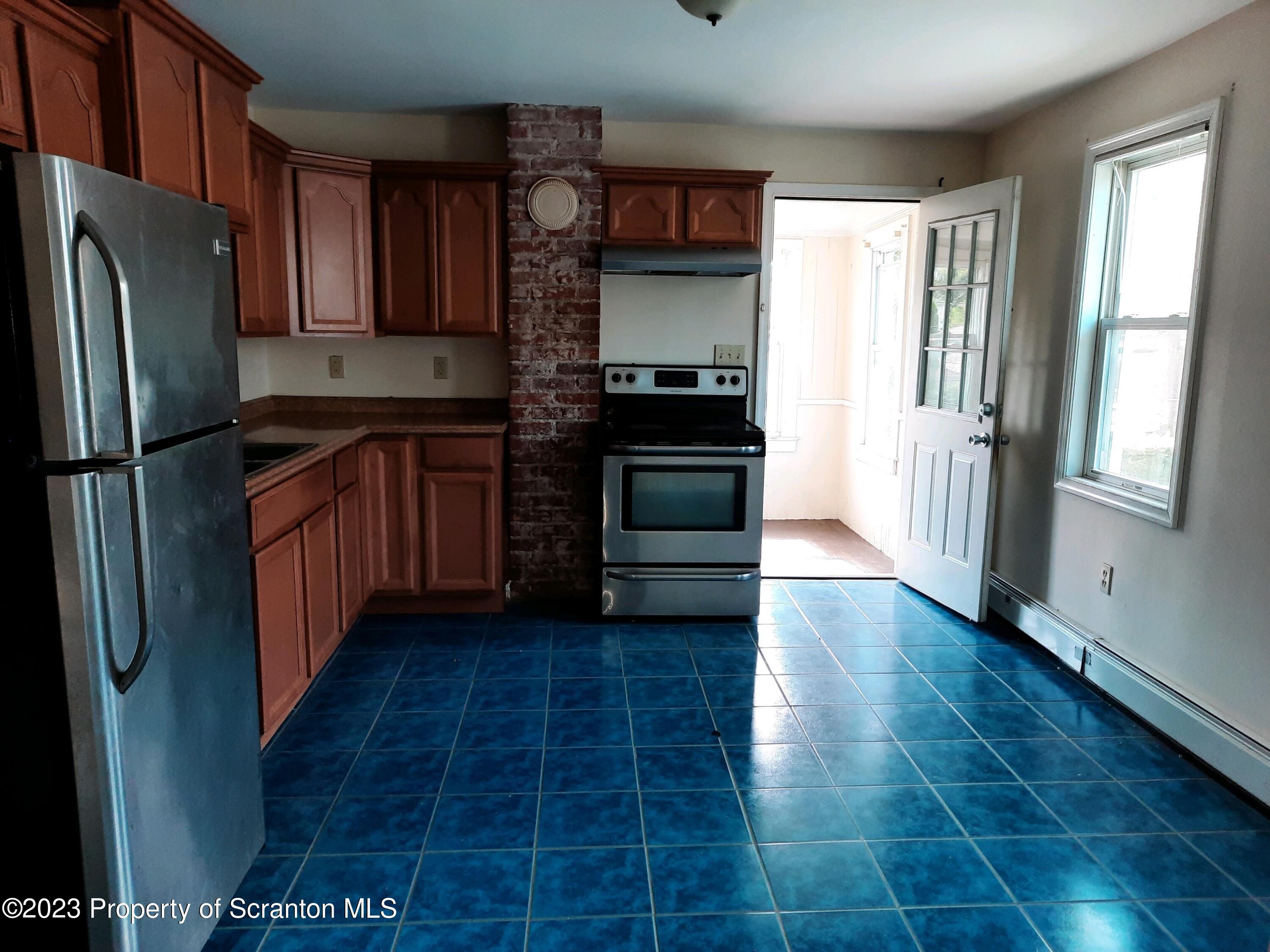 628 East Locust Street Scranton, PA 18505 - Photo 2 of 12 a kitchen with granite countertop a refrigerator and a stove top oven