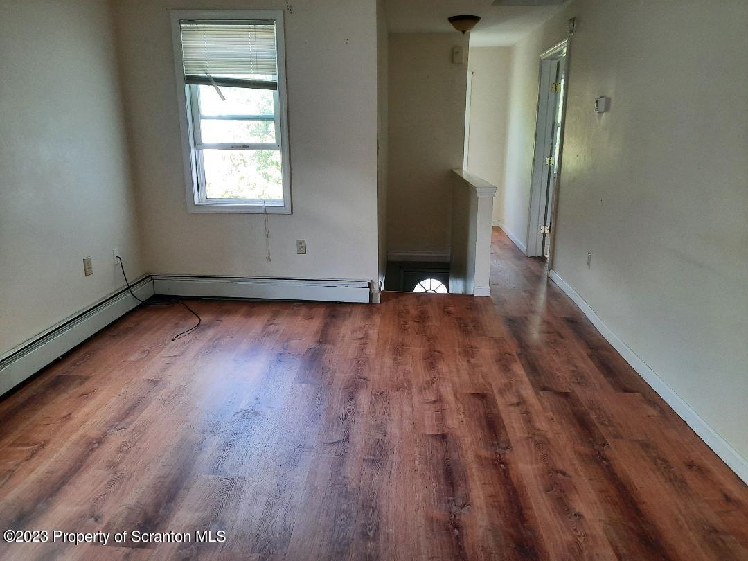 628 East Locust Street Scranton, PA 18505 - Photo 4 of 12 an empty room with wooden floor and windows