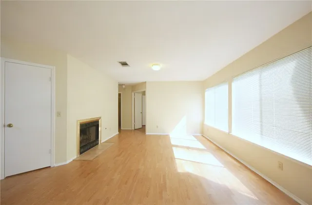 a view of an empty room with a fireplace and a window