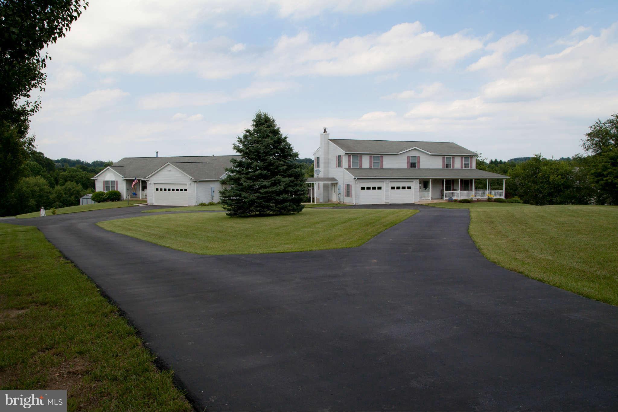 a view of a big house with a big yard plants and large trees