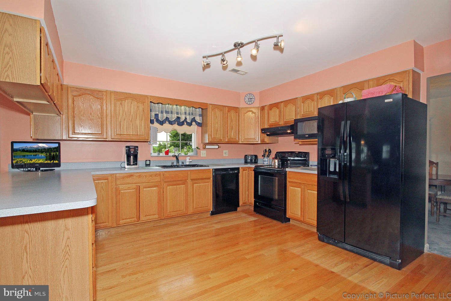 13132 Jesse Smith Road Mount Airy, MD 21771 - Photo 12 of 30 a kitchen with stainless steel appliances kitchen island granite countertop a refrigerator and stove