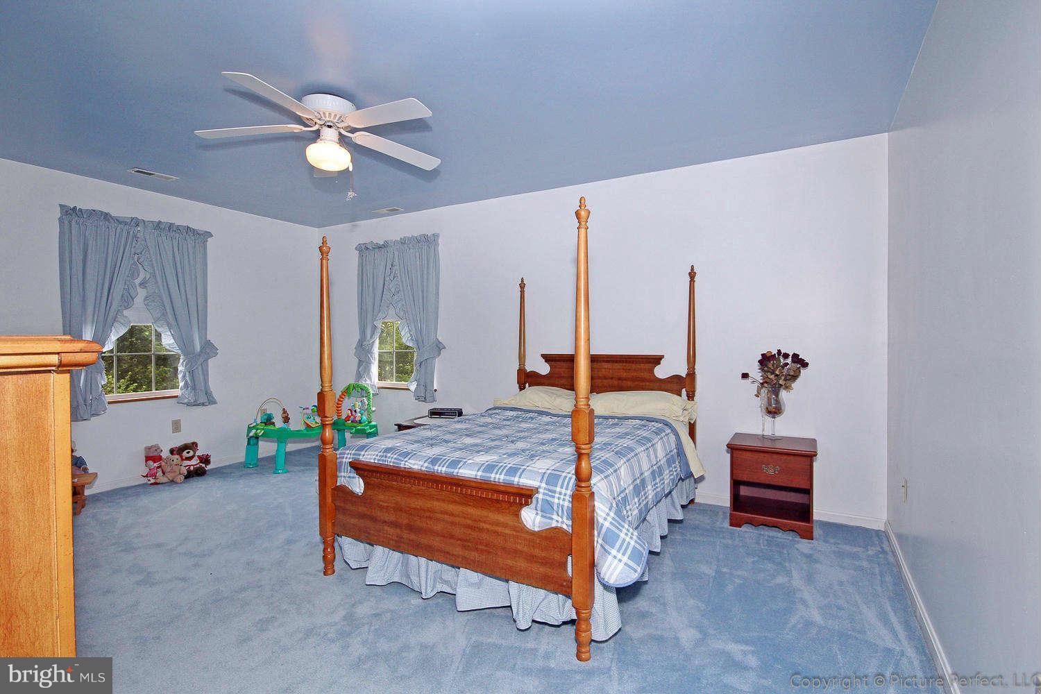 13132 Jesse Smith Road Mount Airy, MD 21771 - Photo 25 of 30 a bedroom with a bed and a chandelier