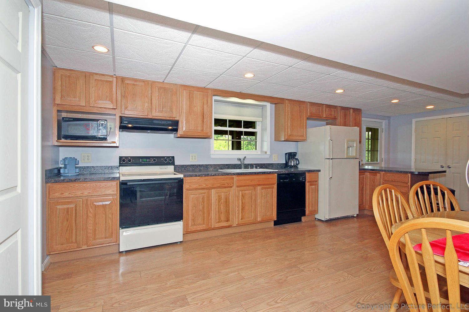 13132 Jesse Smith Road Mount Airy, MD 21771 - Photo 27 of 30 a kitchen with stainless steel appliances kitchen island granite countertop a stove a sink and a refrigerator