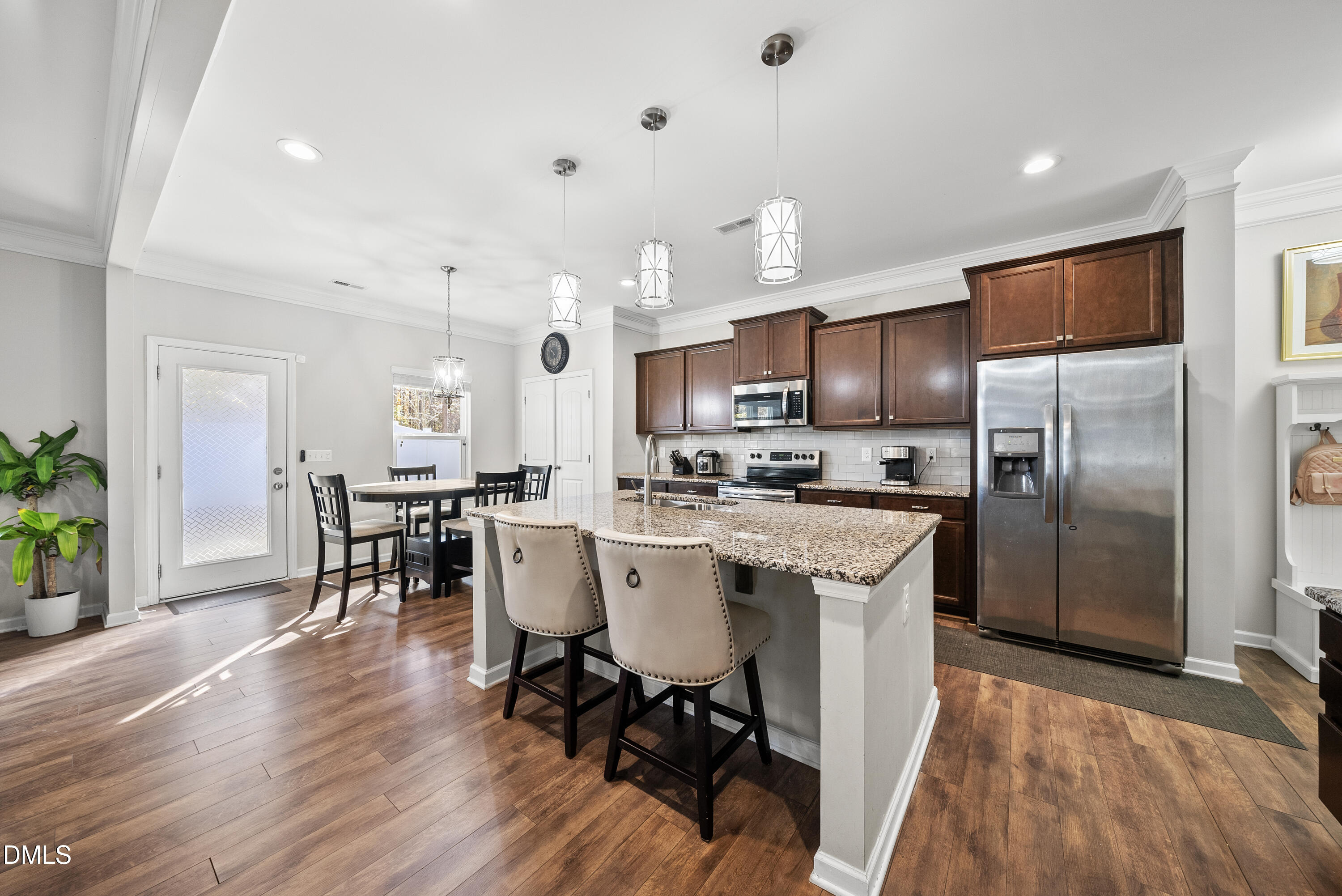 306 Springhill Lane Garner, NC 27529 - Photo 15 of 43 a kitchen with stainless steel appliances a dining table chairs refrigerator and sink