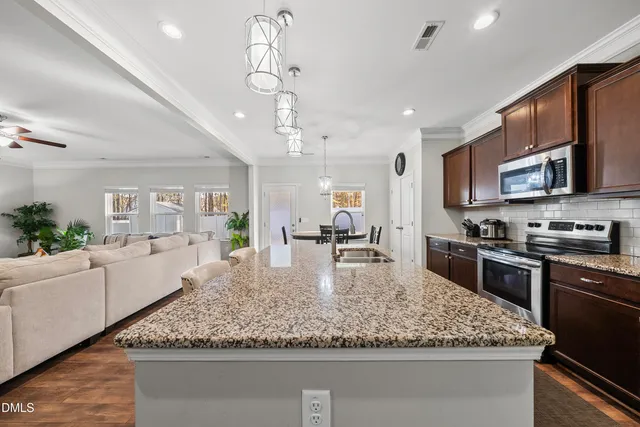 a large kitchen with stainless steel appliances granite countertop a sink stove and refrigerator