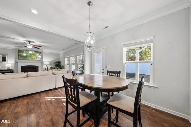 a dining room with furniture a chandelier and wooden floor