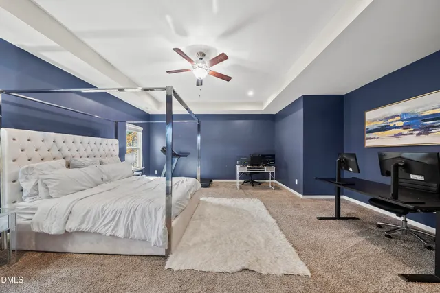a bedroom with a bed a chandelier and a flat screen tv