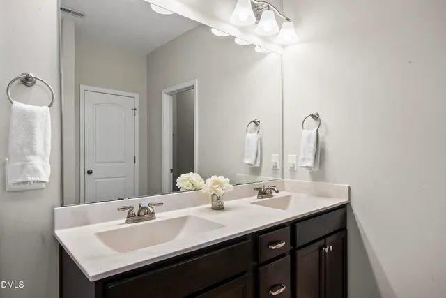 a bathroom with a sink a light fixture and a mirror