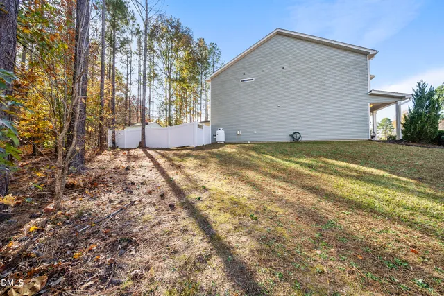 a view of a house with backyard and trees