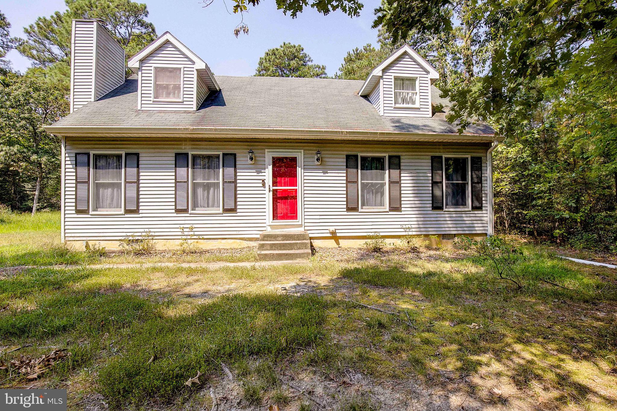 a view of a white house with large windows and a small yard