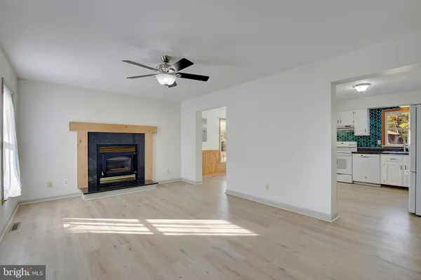 an empty room with windows and fireplace