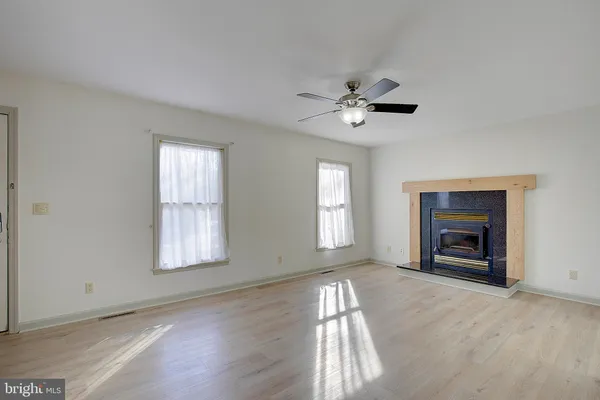 a view of empty room with window and ceiling fan