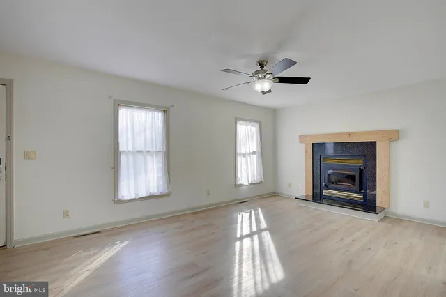 a view of empty room with window and ceiling fan