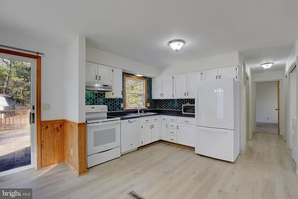 a kitchen with stainless steel appliances a refrigerator and cabinets