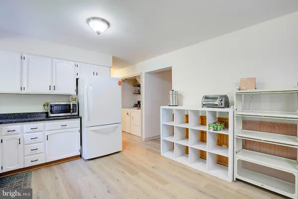 a kitchen with stainless steel appliances granite countertop a stove a sink dishwasher a dining table and chairs with wooden floor