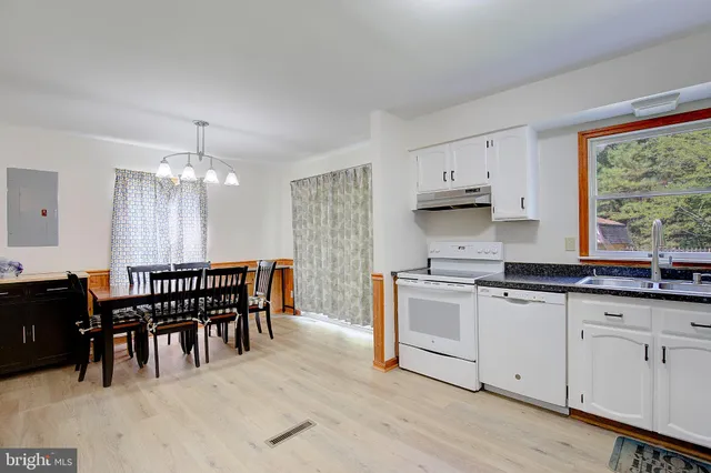 a large kitchen with cabinets wooden floor and stainless steel appliances