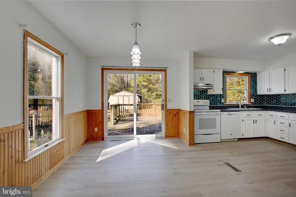 a view of a kitchen with a refrigerator a stove top oven and cabinets