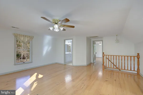 a view of an empty room with window and wooden floor
