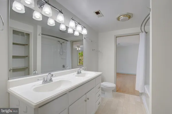 a bathroom with a double vanity sink mirror and shower