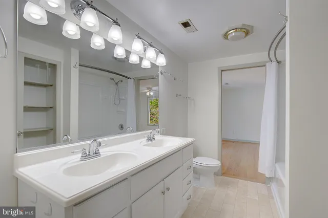 a bathroom with a double vanity sink mirror and shower