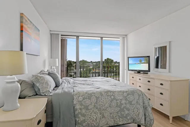 a bedroom with a bed a large window with outer view and balcony view