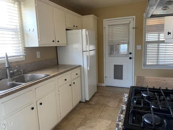 a kitchen with granite countertop a sink stove and refrigerator