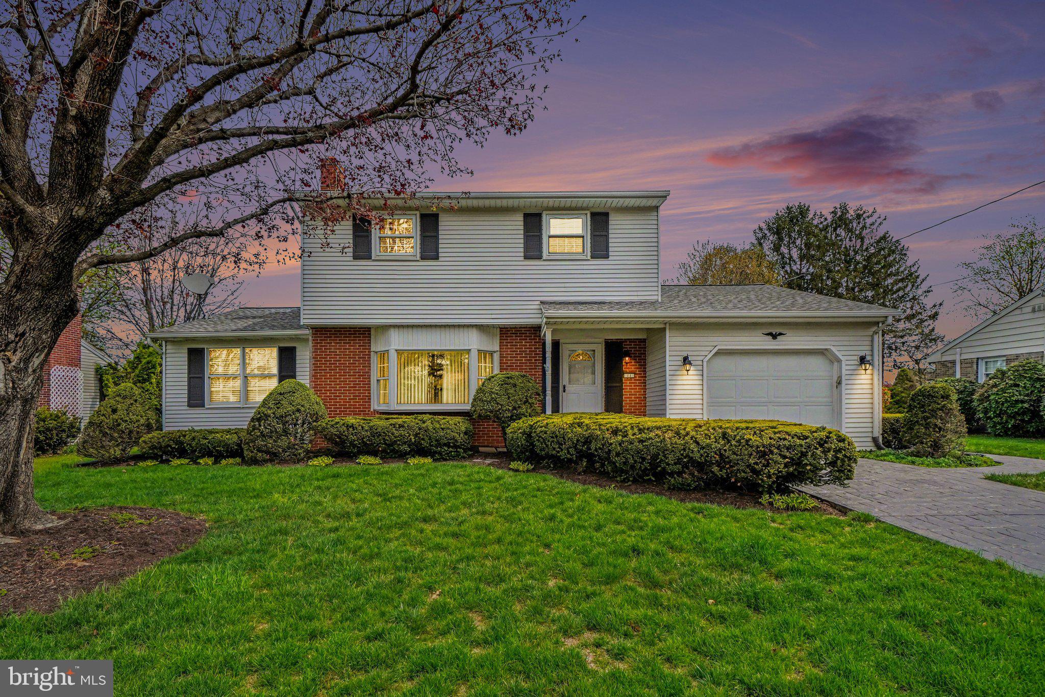 a front view of a house with a yard and trees
