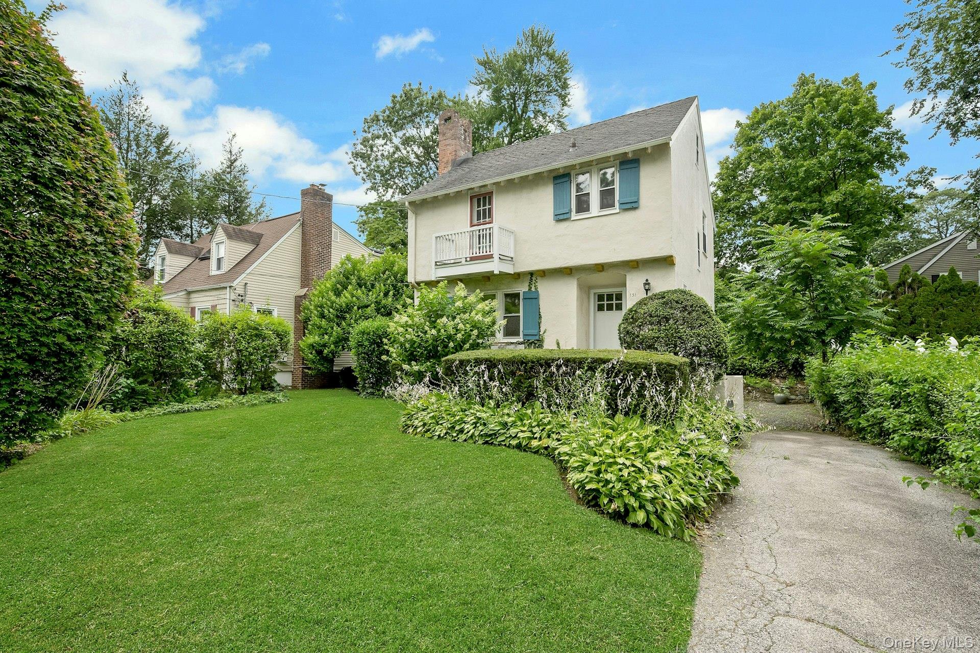 151 Clarence Road Scarsdale, NY 10583 - Photo 2 of 28 a front view of a house with a garden