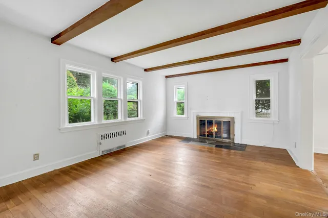 a view of an empty room with window and fire place