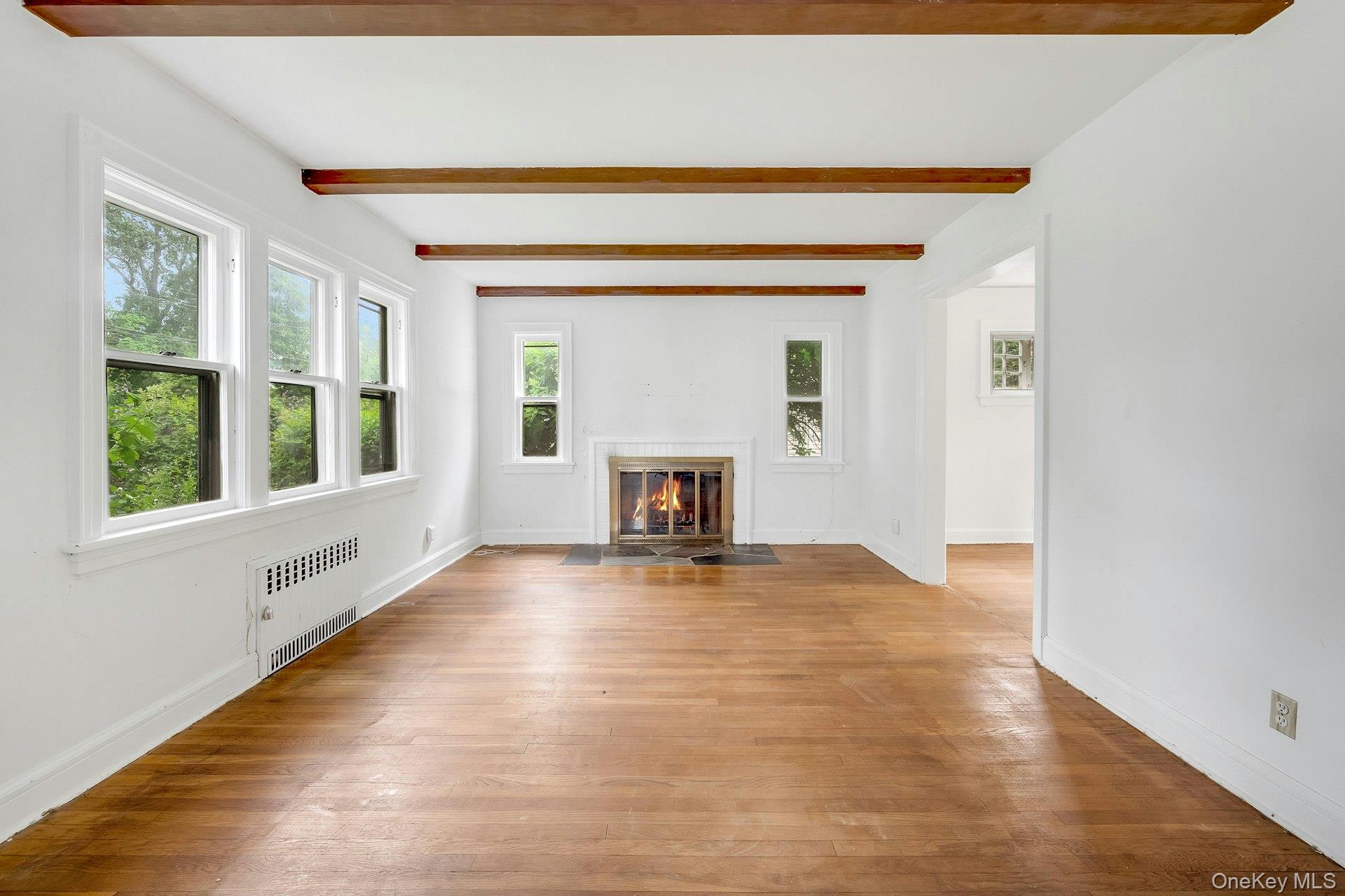 151 Clarence Road Scarsdale, NY 10583 - Photo 5 of 28 a view of an empty room with a window and fireplace