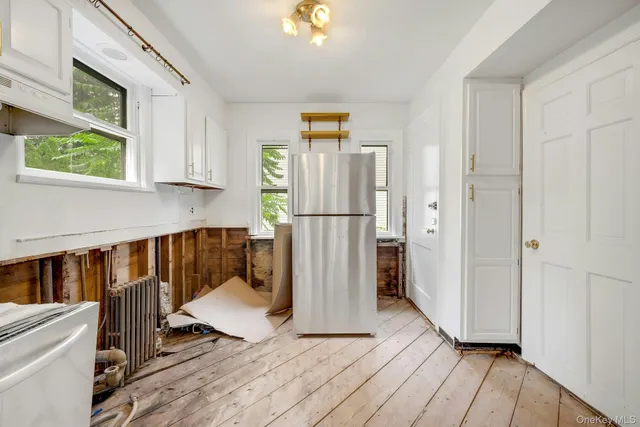 a view of a kitchen with wooden floor and a refrigerator