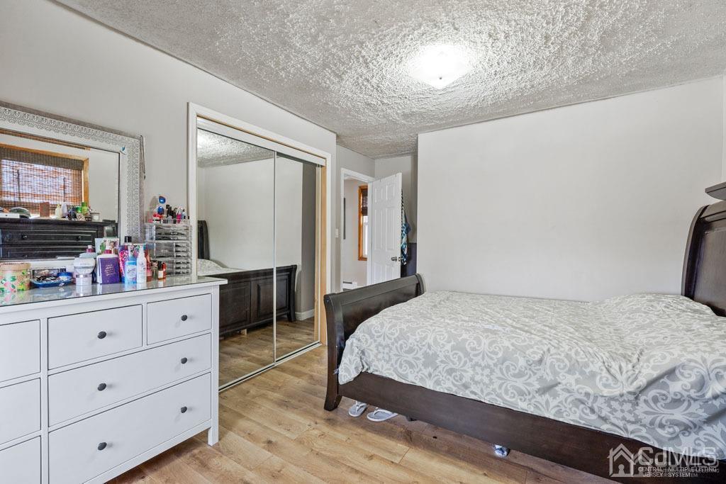 70 County Road Cliffwood, NJ 07721 - Photo 15 of 28 a bedroom with a large bed and a flat tv screen on dresser