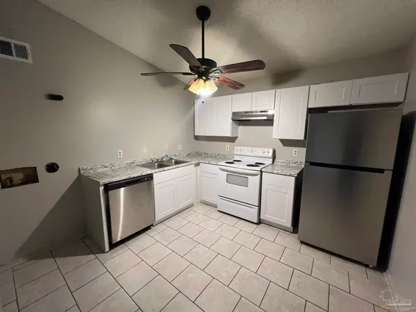 a kitchen with cabinets stainless steel appliances and a counter top space
