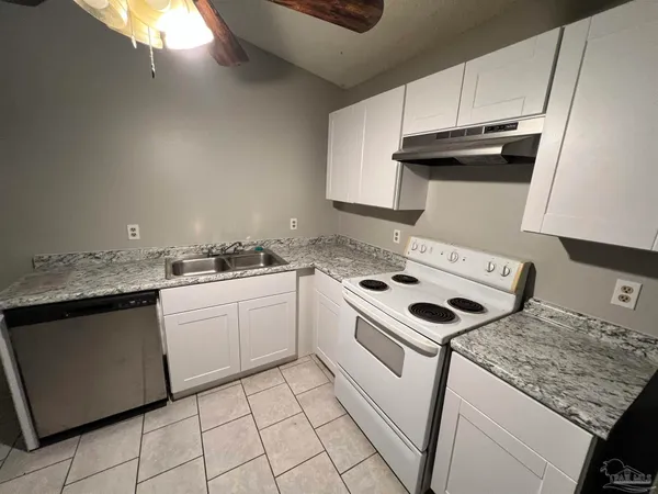 a white stove top oven sitting inside of a kitchen
