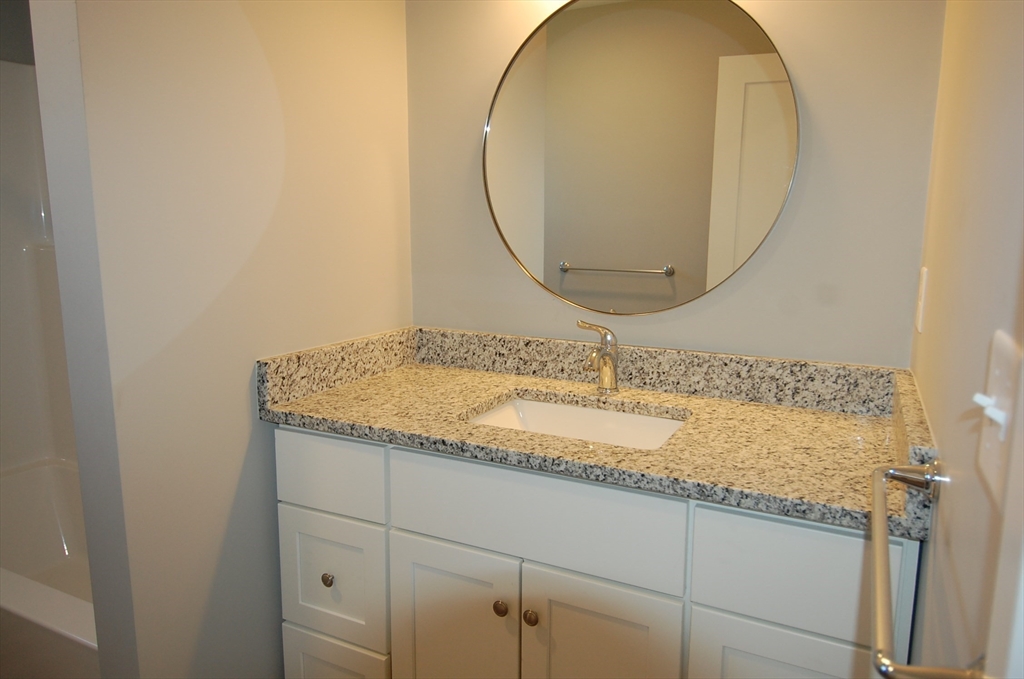 9 Bolton Road, Unit N Dartmouth, MA 02748 - Photo 16 of 19 a bathroom with a granite countertop sink and a mirror