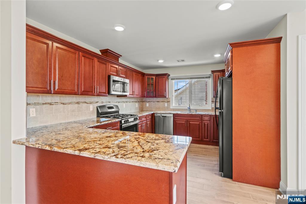 731 Stuyvesant Avenue, Unit 2 Lyndhurst, NJ 07071 - Photo 11 of 24 a kitchen with stainless steel appliances granite countertop wooden cabinets and a counter top space