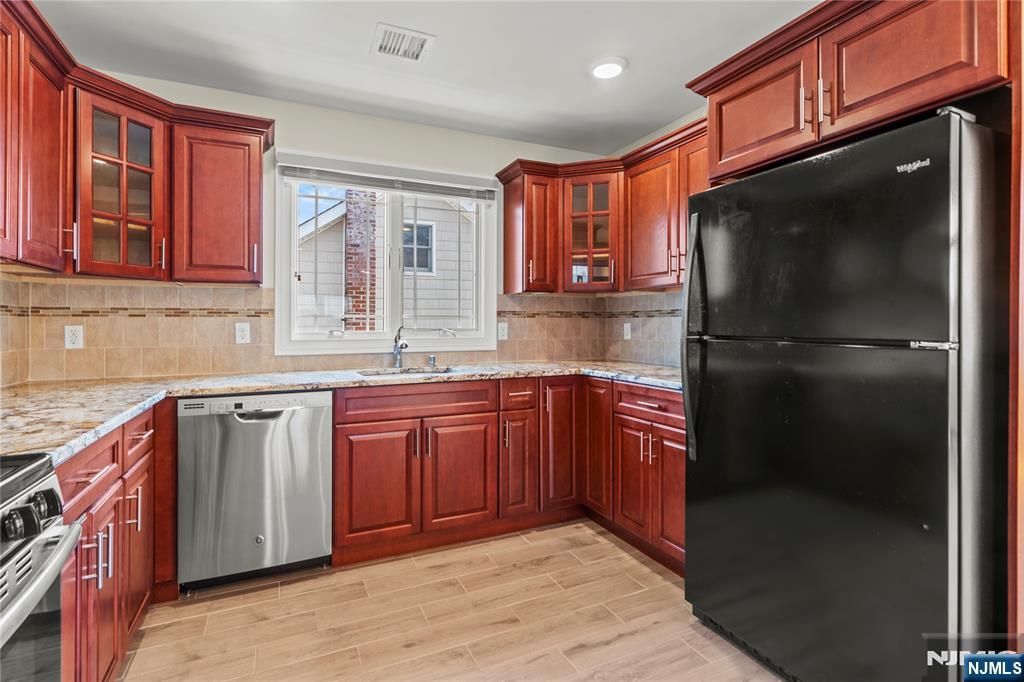 731 Stuyvesant Avenue, Unit 2 Lyndhurst, NJ 07071 - Photo 12 of 24 a kitchen with stainless steel appliances granite countertop a refrigerator and a sink