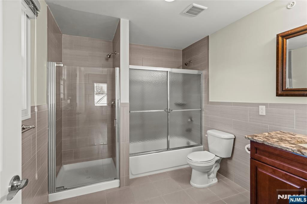 731 Stuyvesant Avenue, Unit 2 Lyndhurst, NJ 07071 - Photo 17 of 24 a bathroom with a granite countertop toilet a sink and a shower