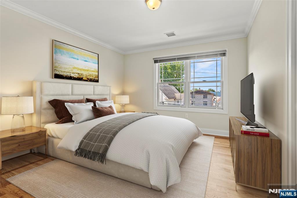 731 Stuyvesant Avenue, Unit 2 Lyndhurst, NJ 07071 - Photo 21 of 24 a bedroom with a large bed and a flat tv screen on dresser