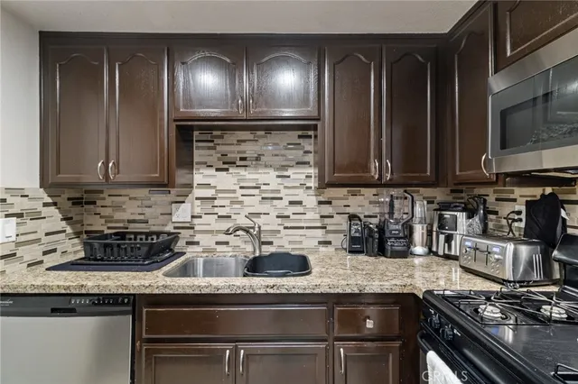 a kitchen with stainless steel appliances granite countertop a stove and a sink