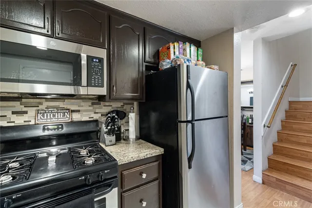 a kitchen with stainless steel appliances granite countertop a refrigerator and a stove top oven