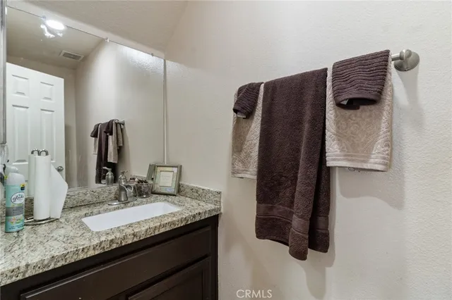 a bathroom with a granite countertop sink and a mirror