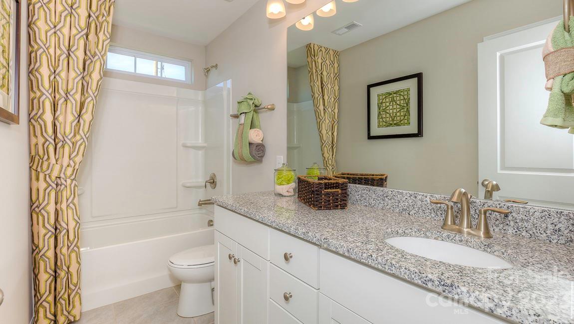 51 Ravens Rdg Road Hendersonville, NC 28792 - Photo 29 of 36 a bathroom with a granite countertop sink a toilet and a bathtub
